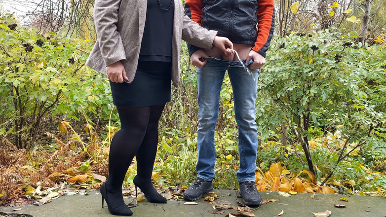 OurFetishLife: 放尿しながら屋外で男のコックを保持しているパンストとスカートに熱い