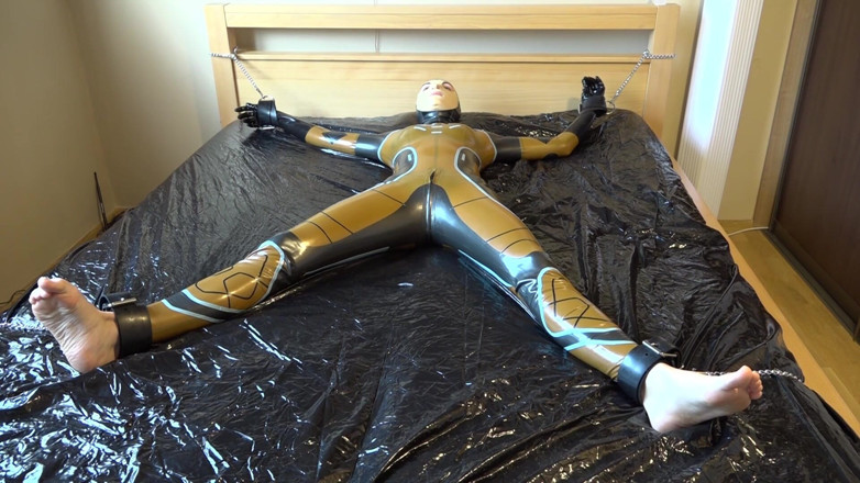 Latex Danielle: Latex Danielle is attached to the bed and masturbated with...