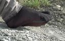 Mistress Legs: Jeans feet in black nylon socks on the seashore