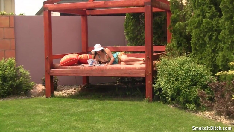 Smoke it bitch: Busty brunette smokes cigarette outdoor on sofa