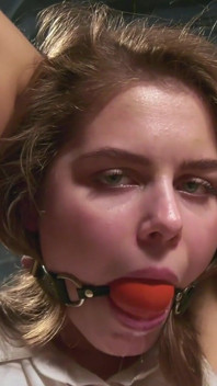 Leya is tied on a chair and drools through ballgag