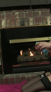 Svůdná brunetka v černém prádle masturbuje u krbu
