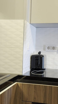 Une nouvelle femme brune sexy dans la cuisine sans culotte avec des collants noirs vérifie les appareils ménagers