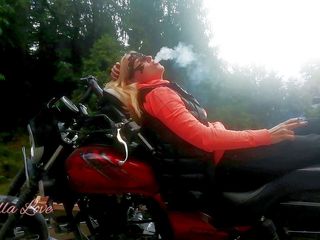 Real fun & fetish: Red lips blonde smoking sensually on Rasta bike outdoor
