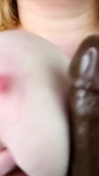 Un grande dildo nero scopata tra le tette e ciuccia