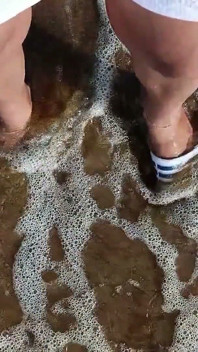 Pies y el mar extra slowmotion - un pie descalzo y un pie en tobogán - grandes pies en el mar
