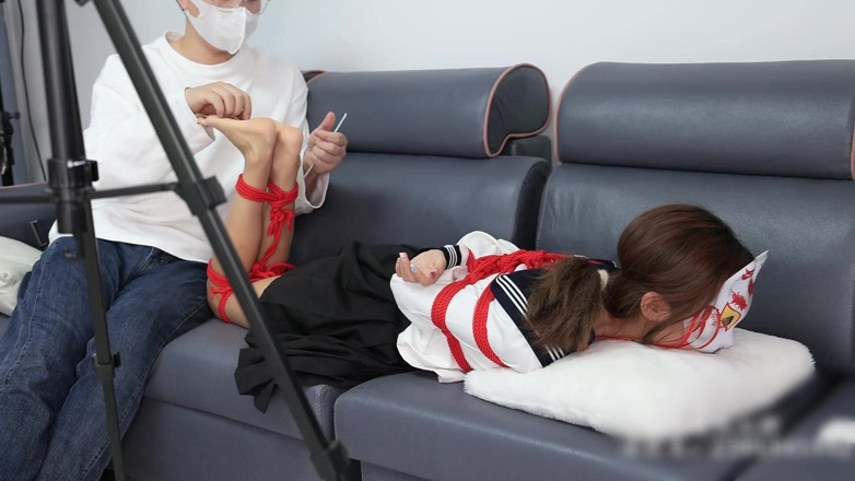 Asian bondage: The Barefoot Girl Is Bound with Red Ropes, Tickling Her...