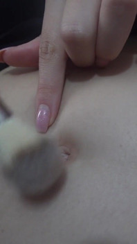Latina stiefzus maakt de navel schoon met een wattenstaaf en na het schoonmaken begint ze met haar buik te spelen