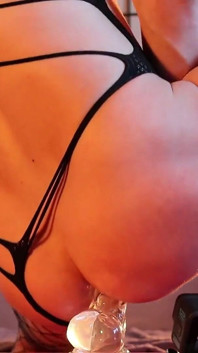 Ein Junge mit einem schönen körper reitet einen großen transparenten dildo