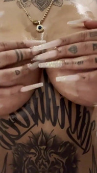 Tatuada milf Tyra muestra tetas aceitadas y coño mojado