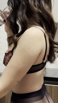 Une nouvelle femme brune sexy dans la cuisine sans culotte avec des collants noirs vérifie les appareils ménagers