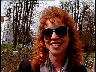 Lucky Cooch: Redhead lady wearing sunglasses while giving an interview