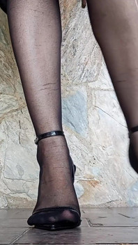 Önünde, taytlı ve stiletto topuklu ayakkabılı sekreter ayaklarından sarkanıyor