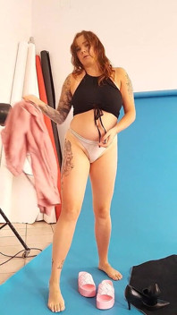Mamma med enorma bröst striptease och klär sig i strumpor medan hon rör vid sig själv.