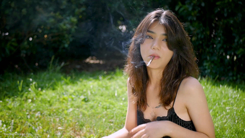 Russian Smokers: Arina Is Smoking One Black Cigarette Outdoors