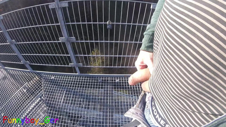 Funnyboy-Ger: Utomhus, på ett mycket offentligt utsiktstorn vid en flod, arbetar...