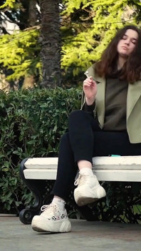 Young Brunette Is Taking an Unhurried Stroll with Allwhite 120mm Cigarette