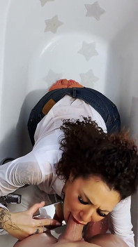 De vrouw in spijkerbroek en shirt stapt het bad in, gekleed om lul te pijpen!