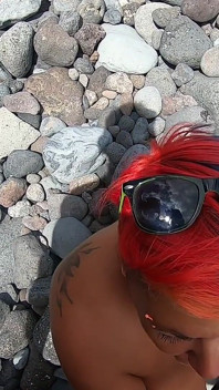Mi esposa desnuda de pelo corto chupa mi polla al aire libre en una playa