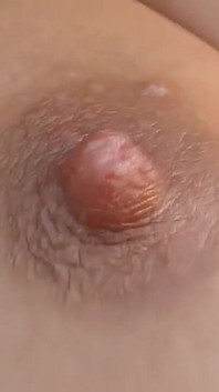 Uma garota com tesão com dois peitos bonitos e cabelo vermelho se masturba com um brinquedo sexual fora
