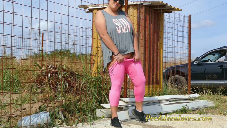 Pee Adventures: 戴着太阳镜的胖黑发女郎在一条土路上尿在紧身衣里，然后在房子前的混凝土上撒尿