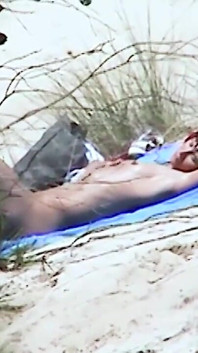 Redhead beauty dildoing pussy on the sandy beach