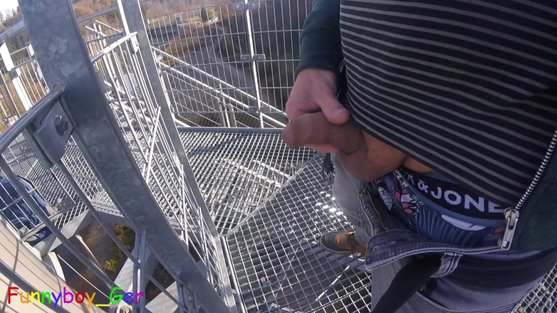 Funnyboy-Ger: Utomhus, på ett mycket offentligt utsiktstorn vid en flod, arbetar...