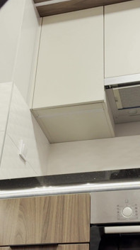 Hete nieuwe tengere brunette vrouw in de keuken Geen slipje met een zwarte panty controleert de apparatuur
