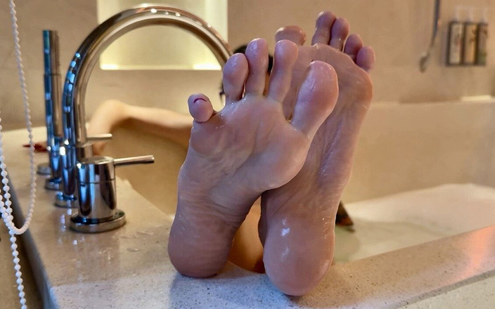 Julia domaina: 浴槽の中のピンクの靴底、長いつま先を持つ素足、濡れたしわの寄った足の裏