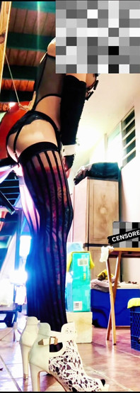 Une trans sexy vêtue de bas chevauche un gode anal au mur