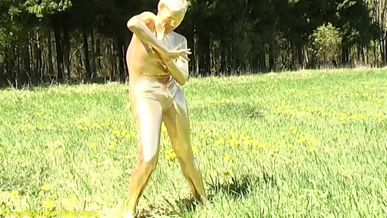Fetish Islands: Sexy zwarte babe in strakke gouden spandex catsuit poserend buitenshuis