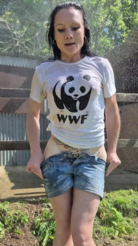 Tiempo de juego de camisetas mojadas: enfríandose bajo una ducha fría al aire libre