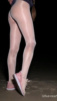 Anna in white shiny pantyhose on the night beach