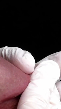 Juego de glande con guantes de látex blancos en super primer plano