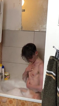 Un garçon mince se branle sous la douche