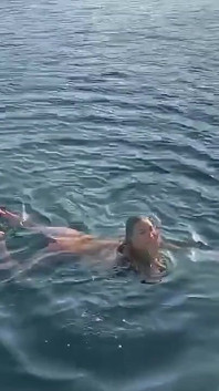 Monika Fox nadando desnuda en la bahía por la mañana