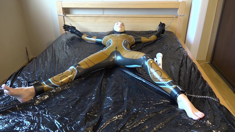 Latex Danielle: Latex Danielle is attached to the bed and masturbated with...