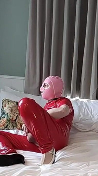 Heiße maskierte spermaschlampe in voll rotem pvc-catsuit