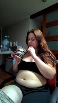 Mujer gordita caliente llenando su vientre redondo con algunos dulces