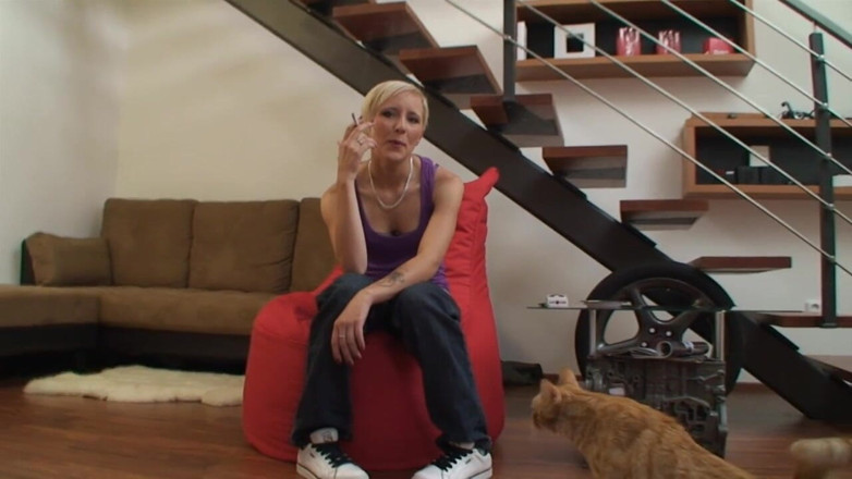Facial flavor: Blonde girl sits on the couch and smokes her cigarette