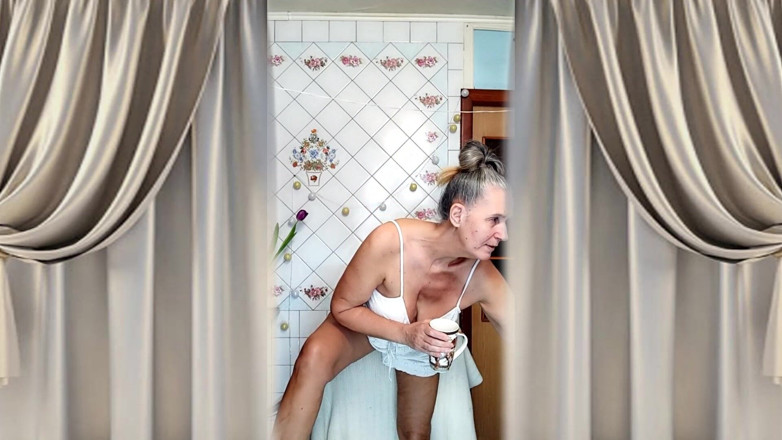 Lukerya: Gospodina sexy matură Lukerya în White Tank Top și pantaloni scurți tachinează și...