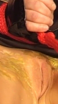 Une MILF brune à forte poitrine endure de la cire ardente et des pinces