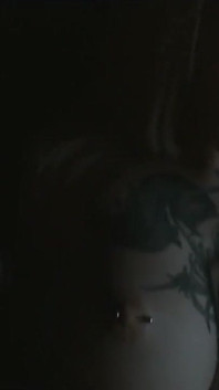Tattooed teen is dancing in the dark room
