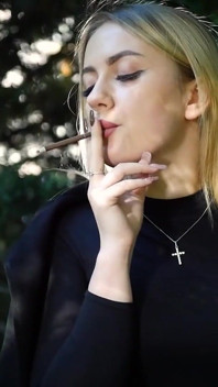 Hot Blonde Babe Smoking Two Black Cigarettes in Nature