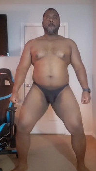 Grande urso preto beefy em uma tanga